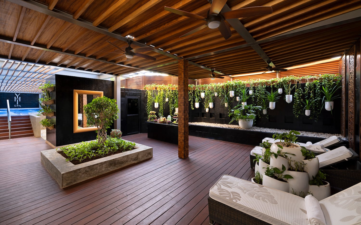a patio with plants and a ceiling fan