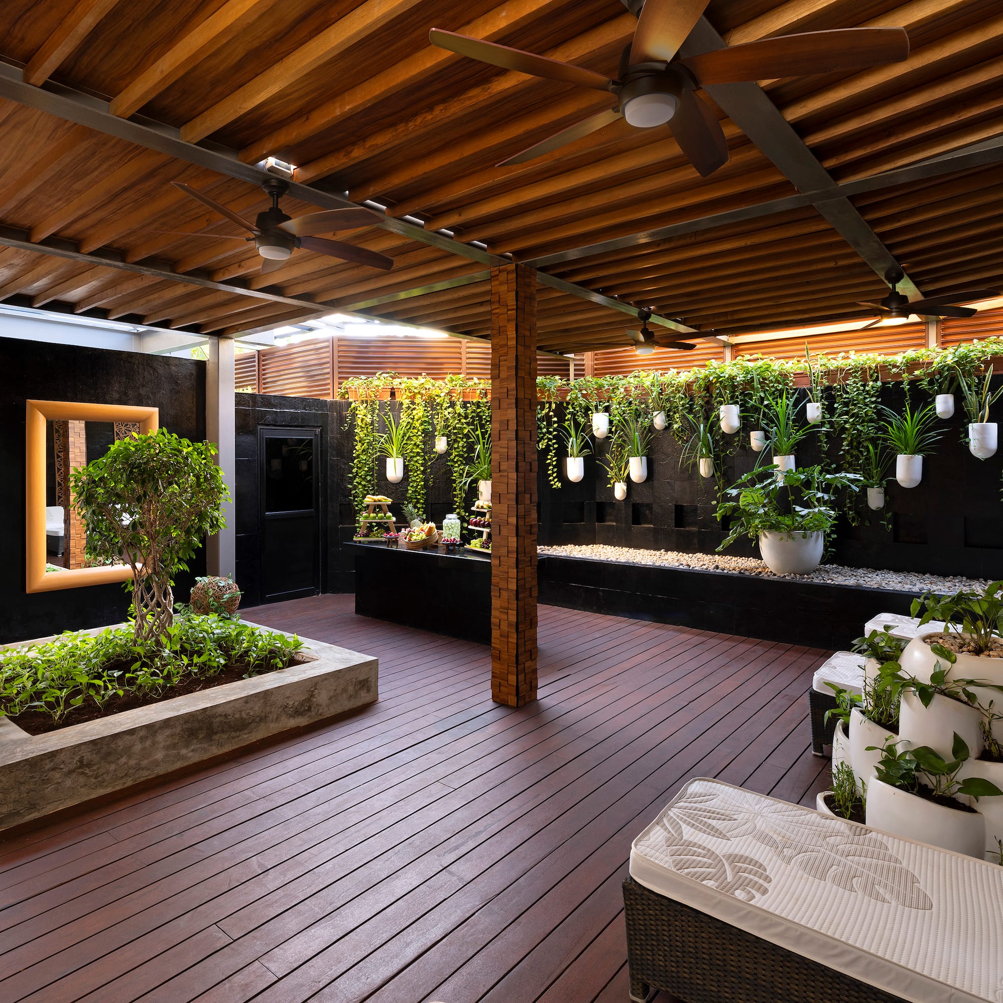 a patio with plants and a ceiling fan