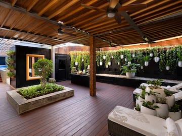 a patio with plants and a ceiling fan