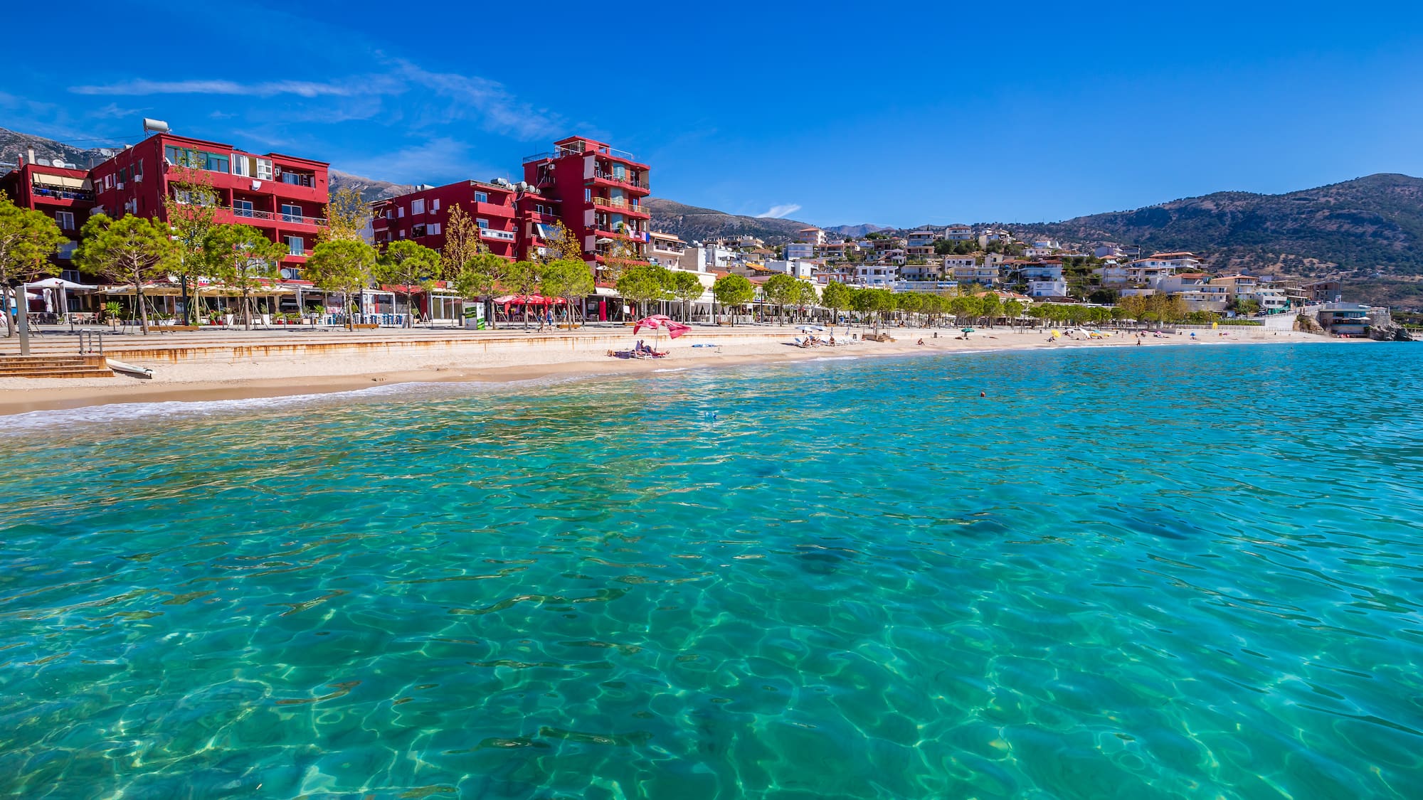 a beach with buildings and a body of water