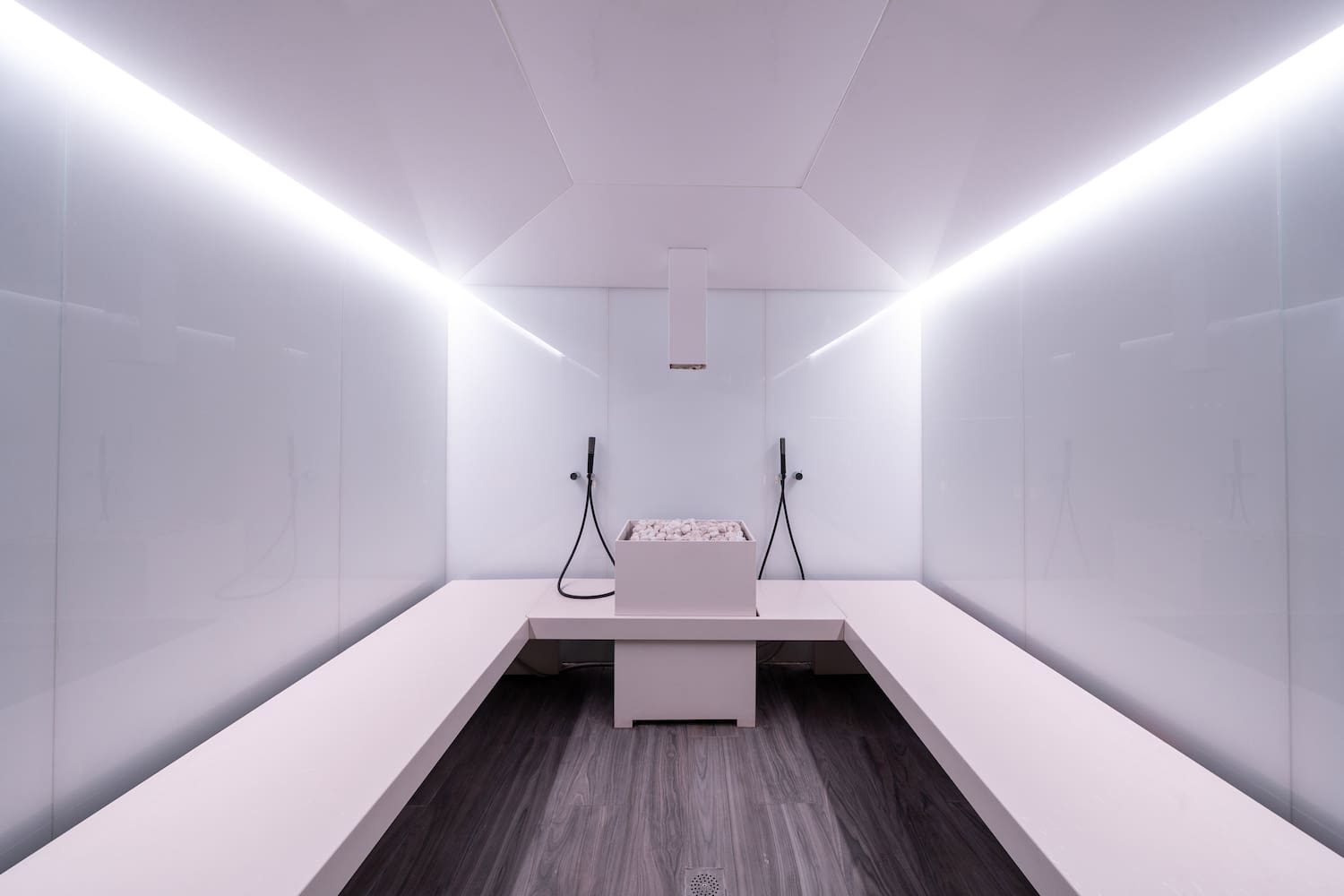 a white room with a bench and a bucket of water