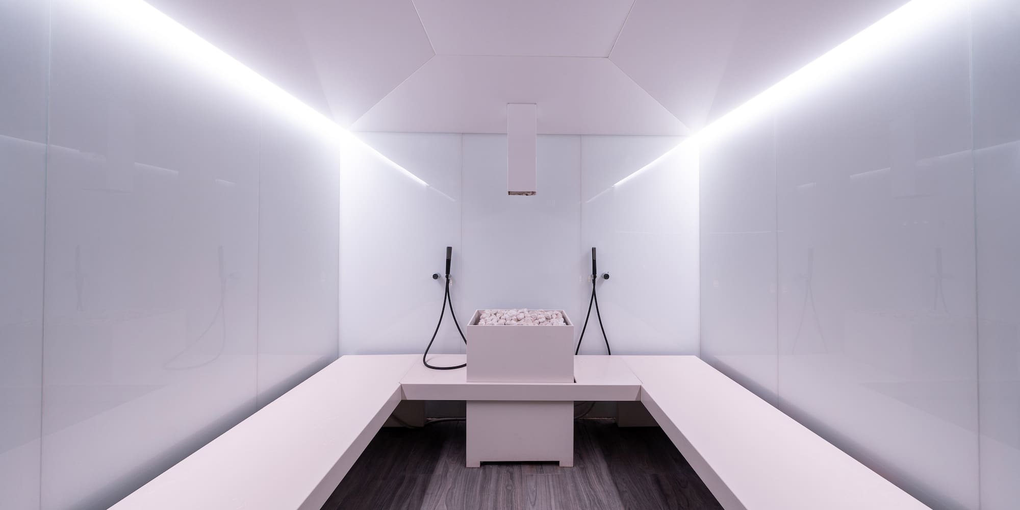 a white room with a bench and a bucket of water