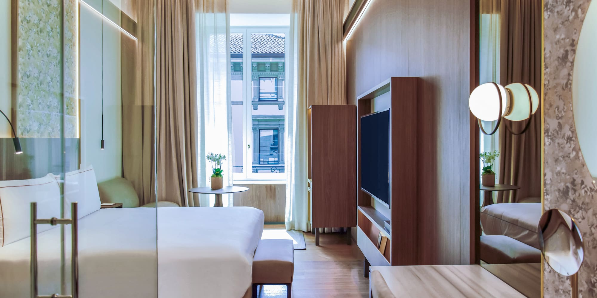 City Views from the Deluxe room with a bed and a television at Palazzo Cordusio Gran Melia Hotel