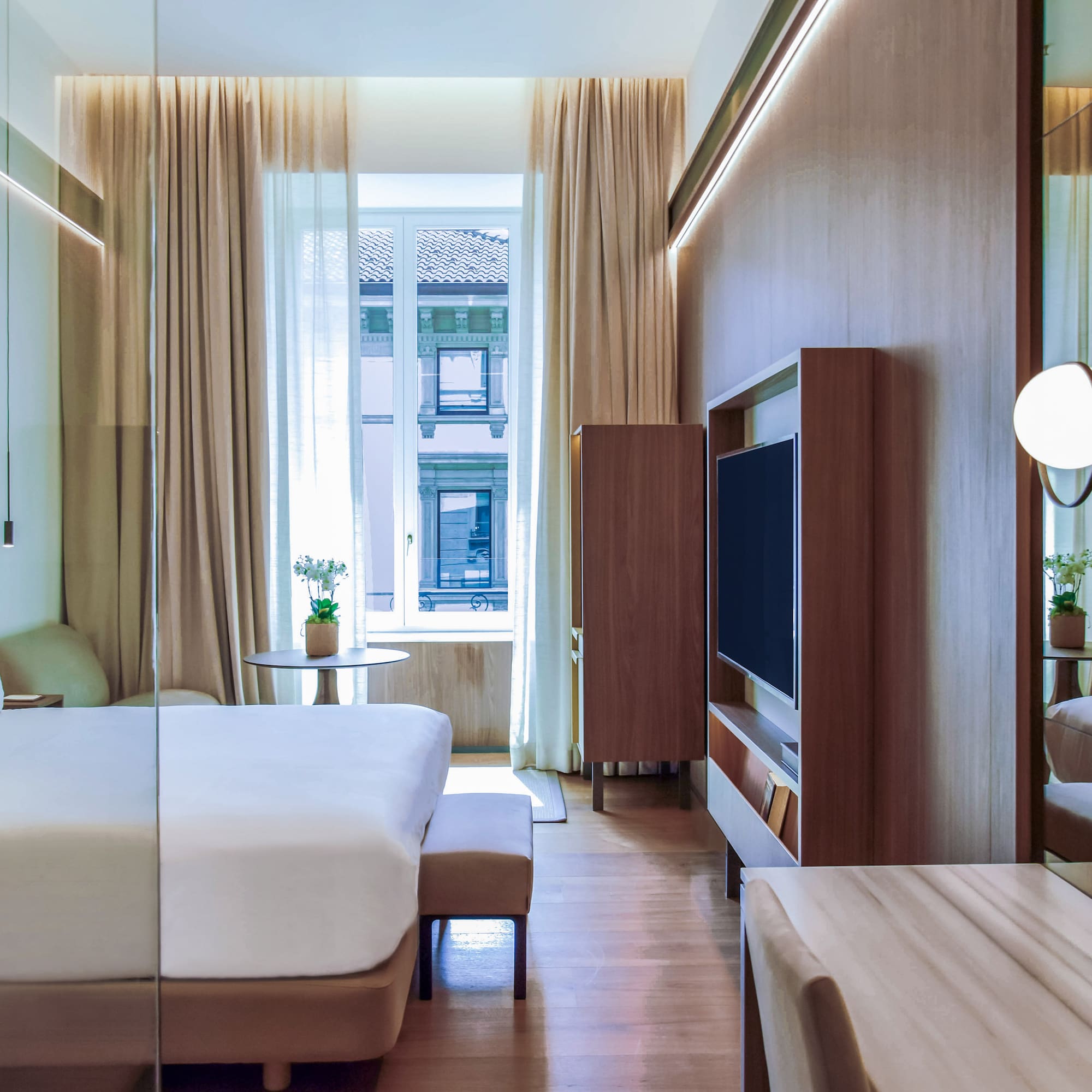 City Views from the Deluxe room with a bed and a television at Palazzo Cordusio Gran Melia Hotel