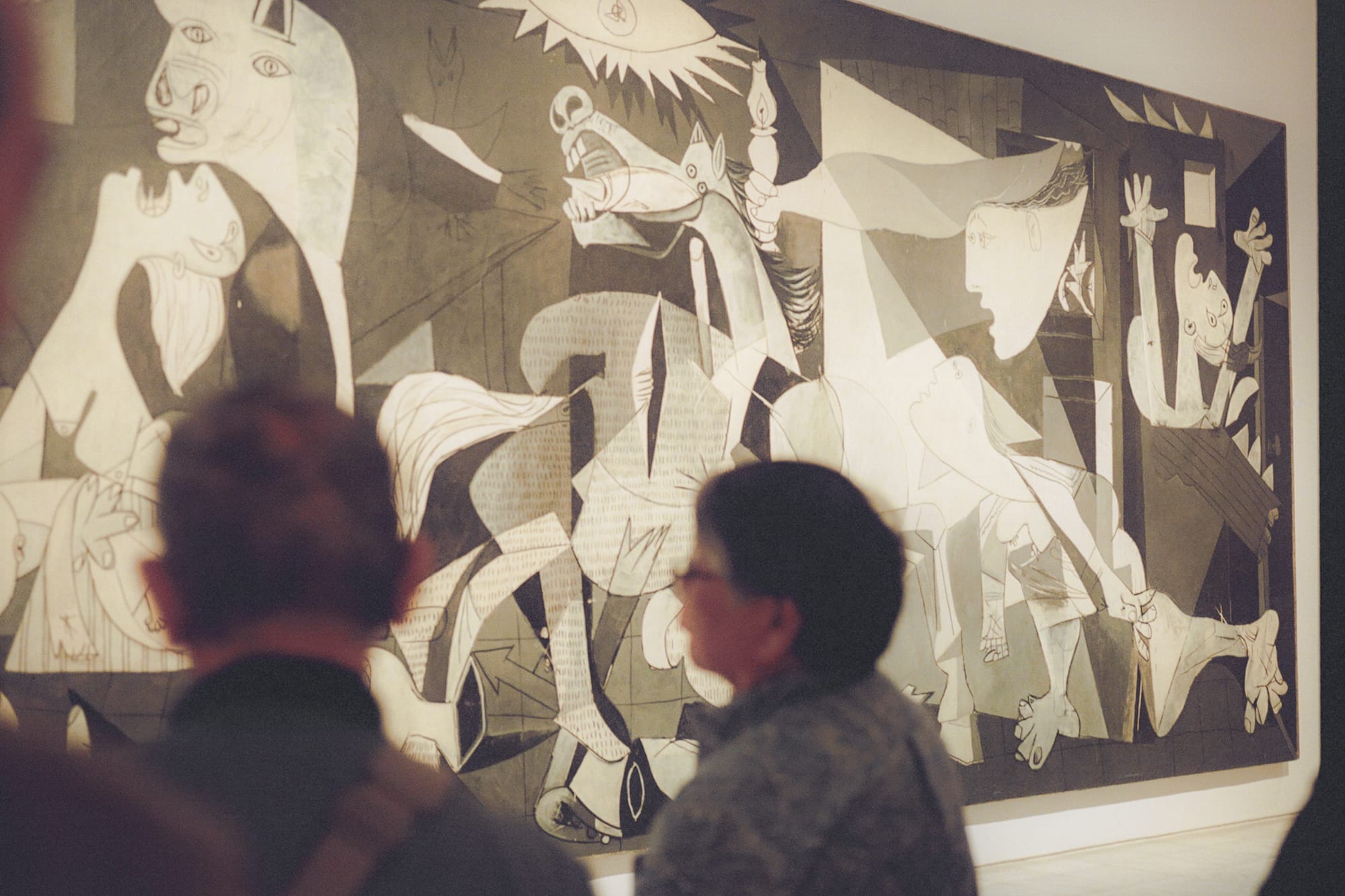 a group of people looking at a large painting