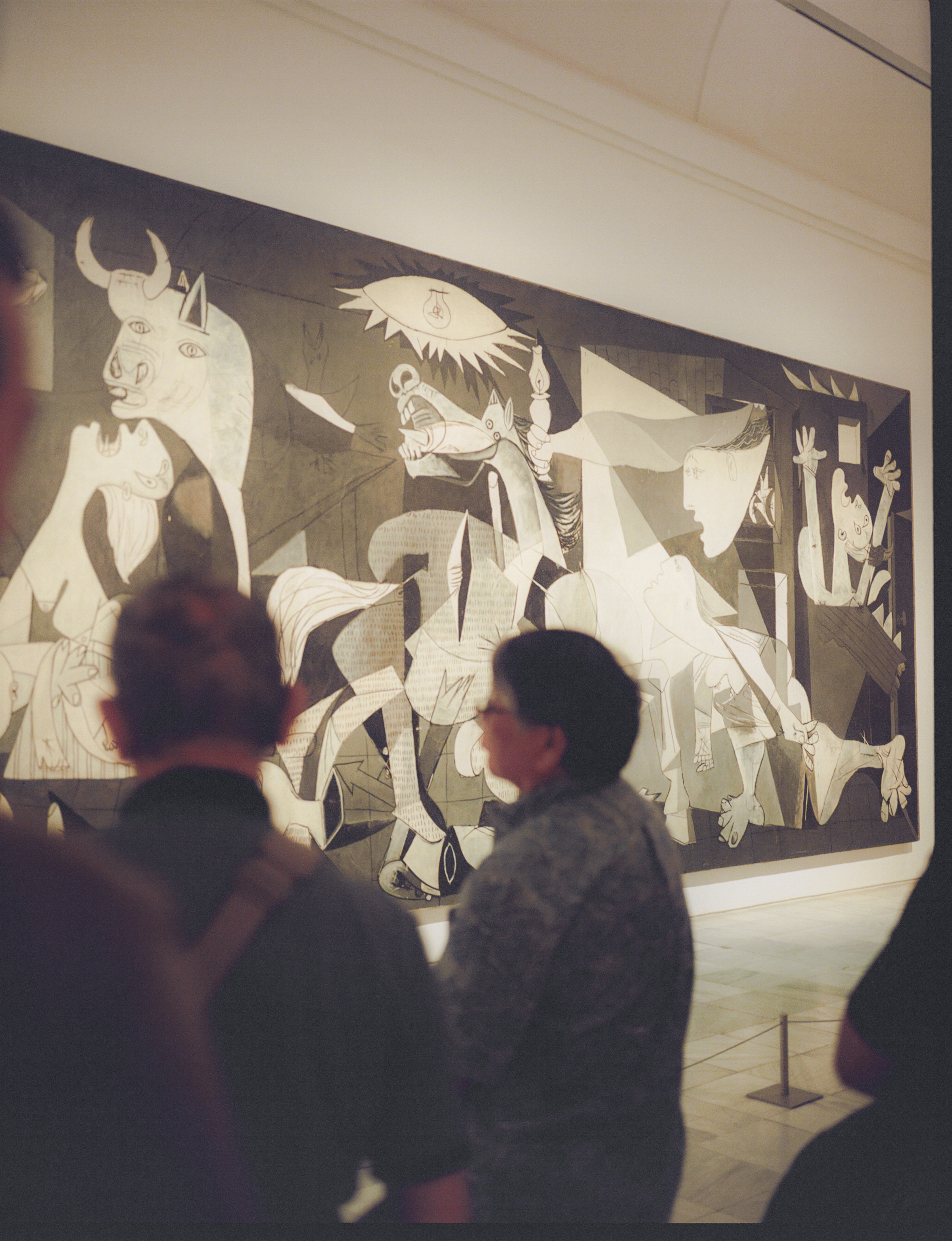a group of people looking at a large painting