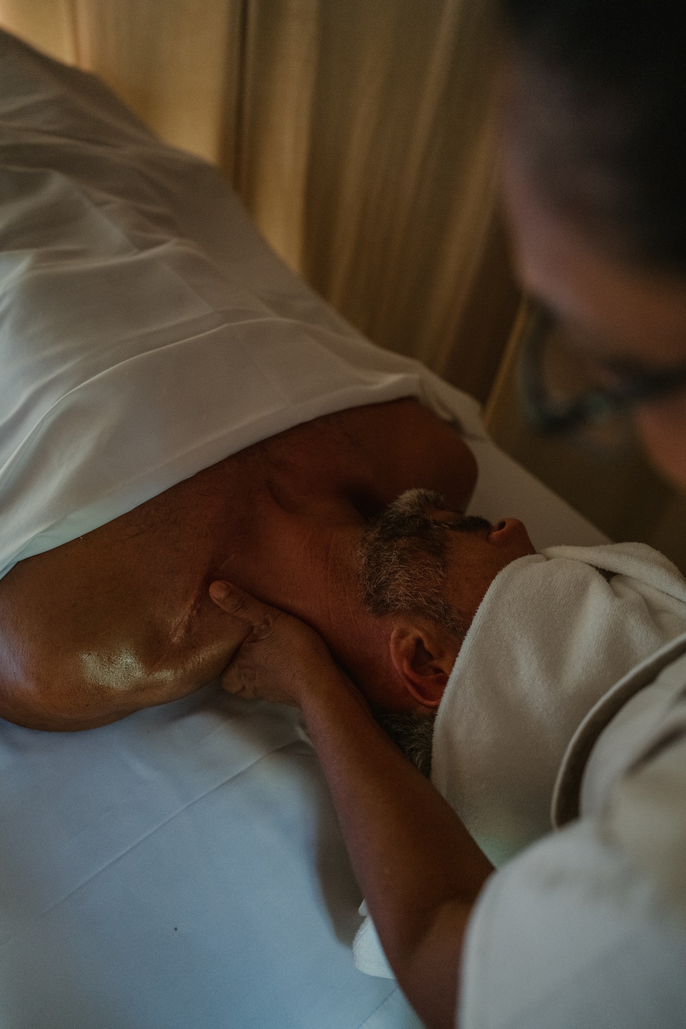 a man lying on a bed with his neck