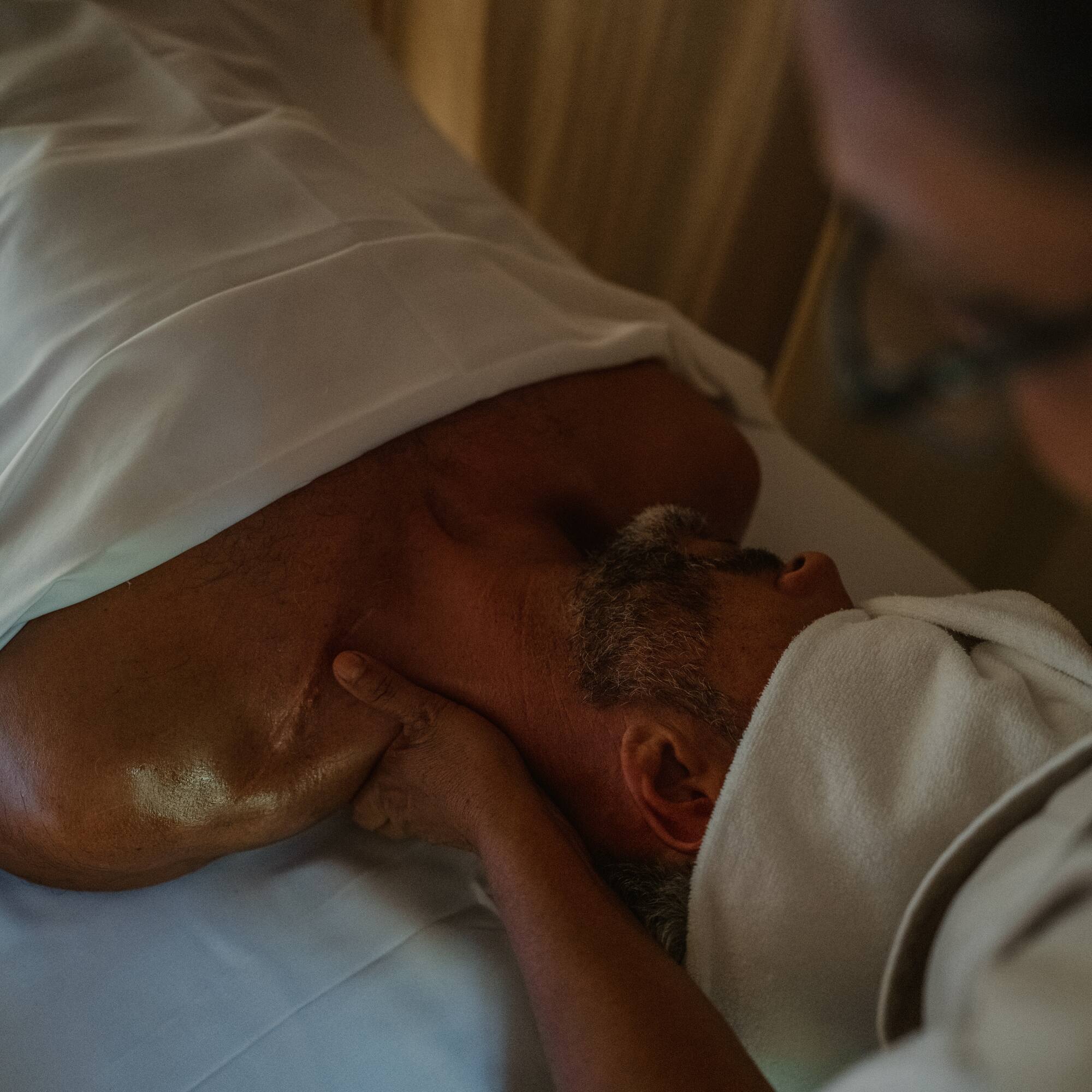 a man lying on a bed with his neck
