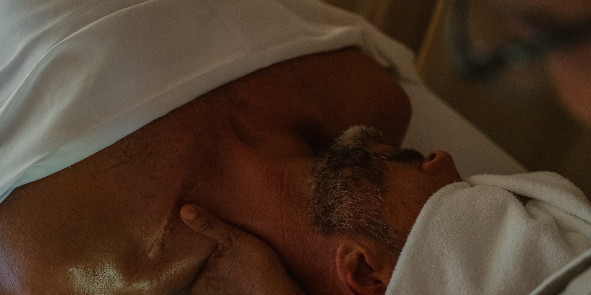 a man lying on a bed with his neck