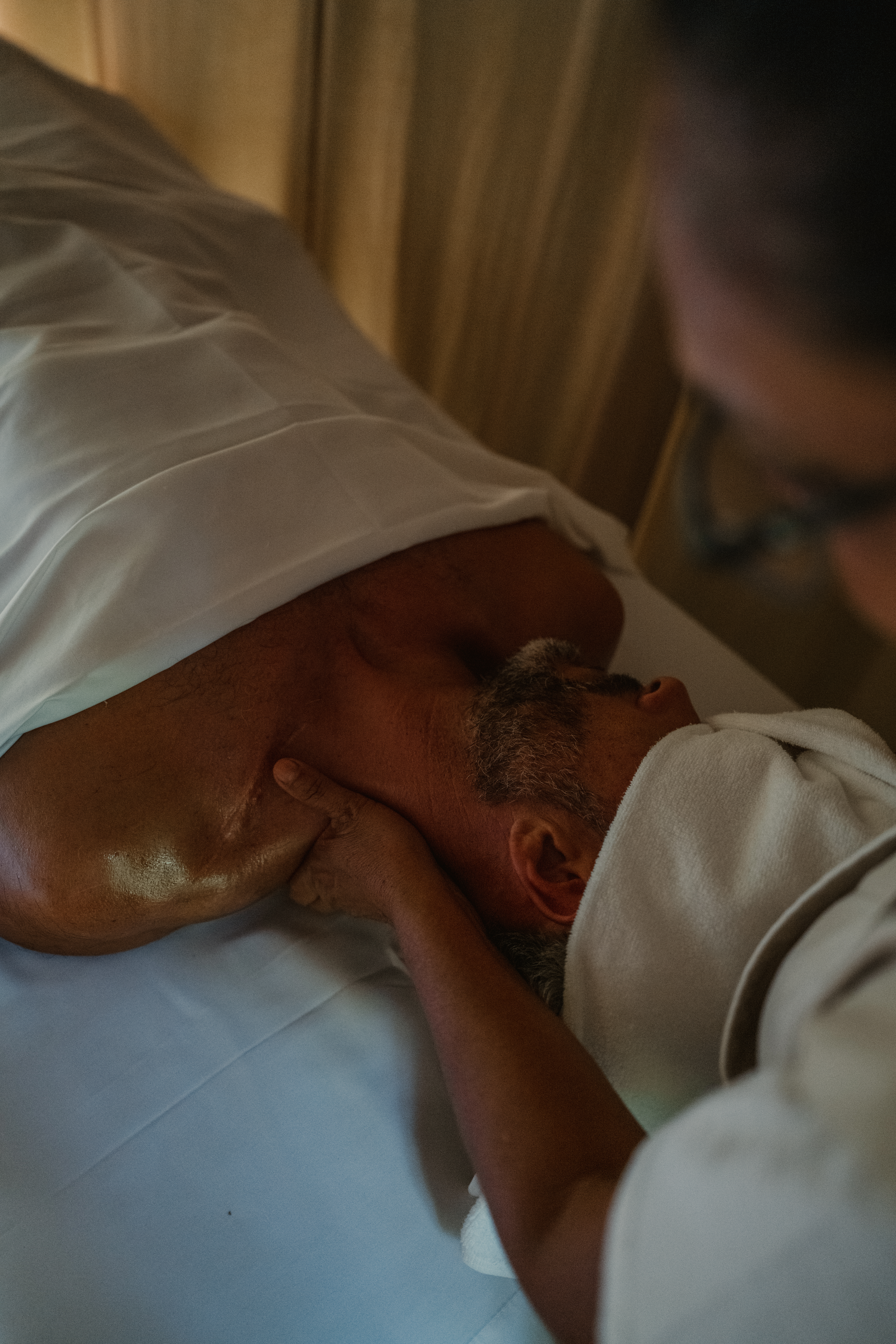 a man lying on a bed with his neck