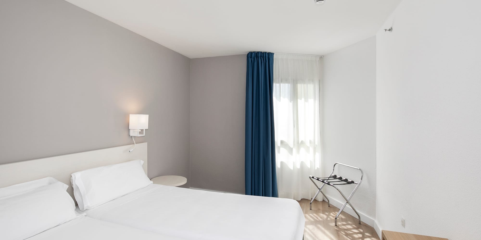 a room with two beds and a lamp