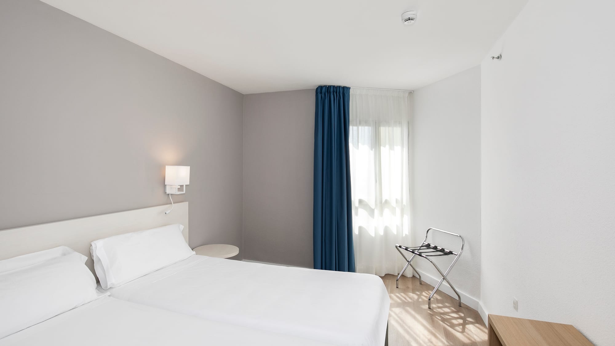 a room with two beds and a lamp