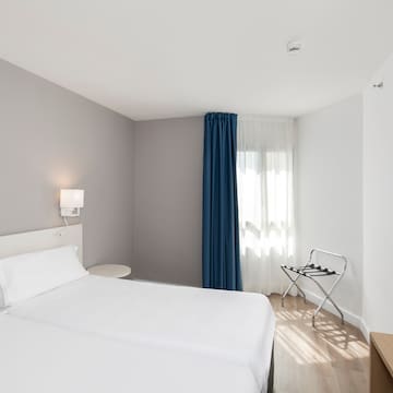 a room with two beds and a lamp