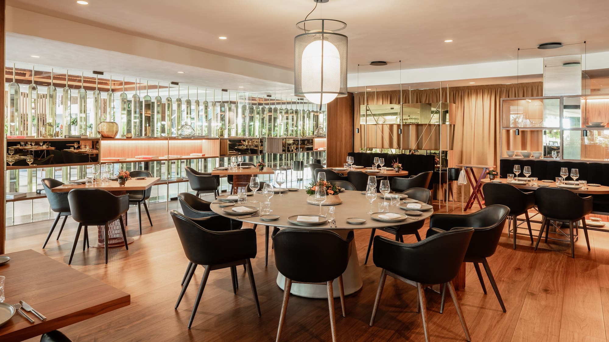 a room with a large round table and chairs
