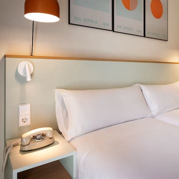 a bed with a telephone on a table