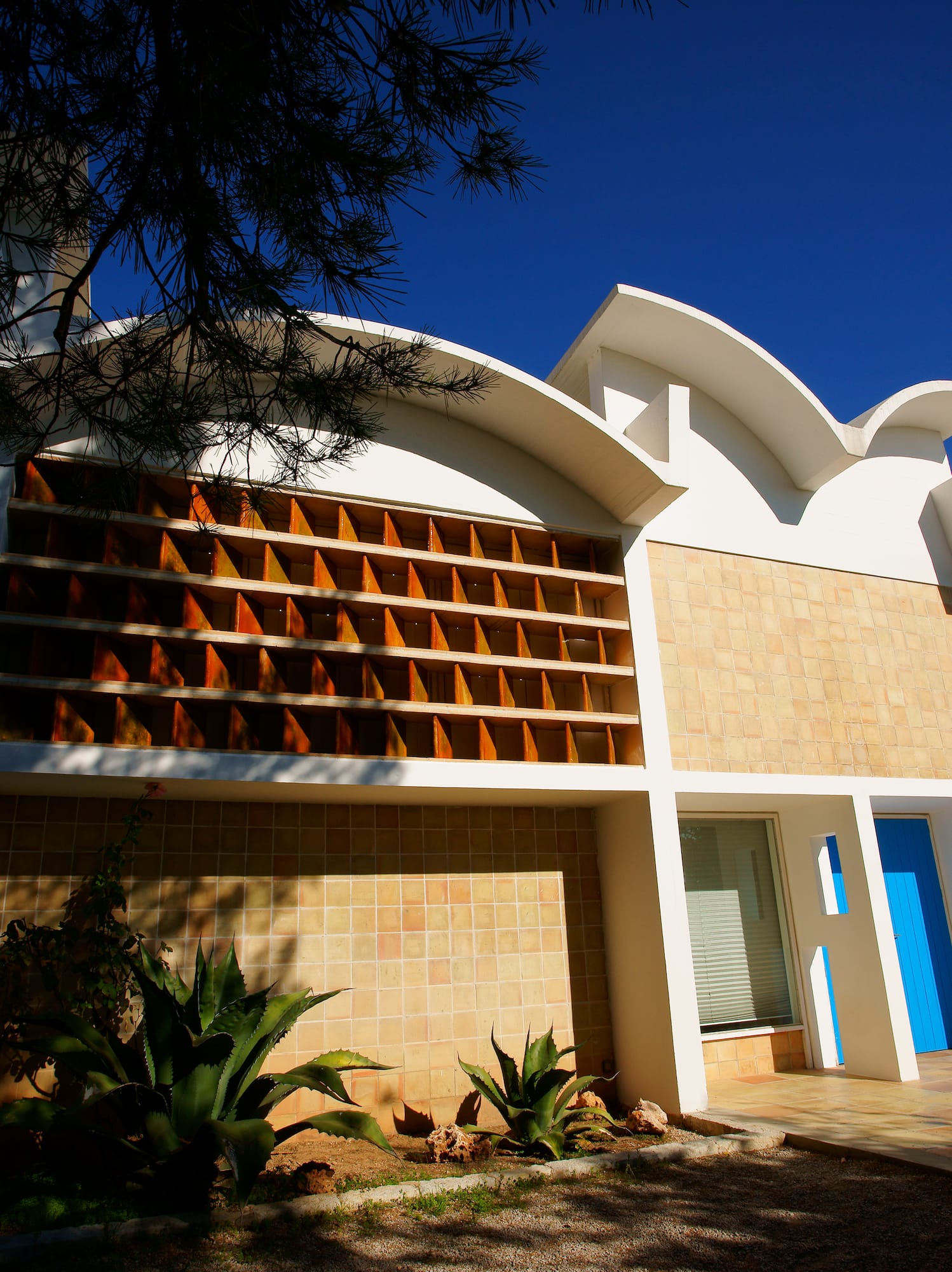 a building with a blue door and a tree