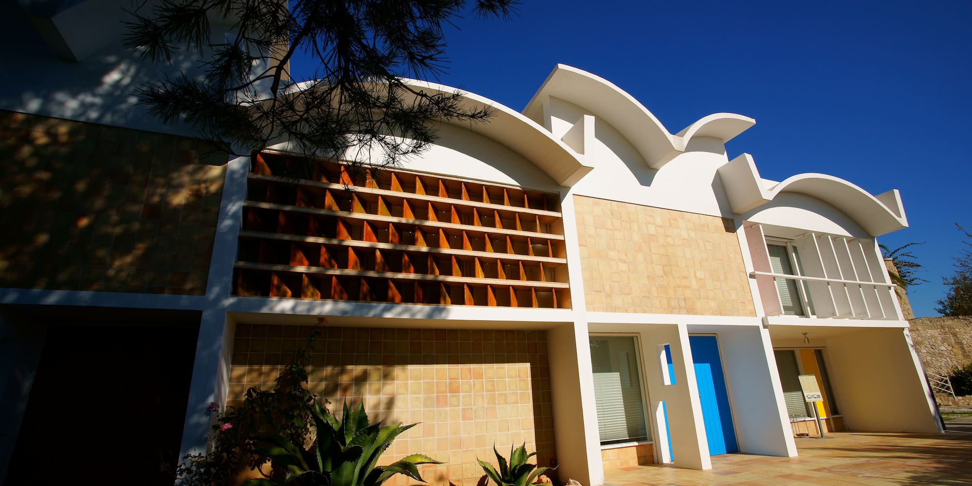 a building with a blue door and a tree