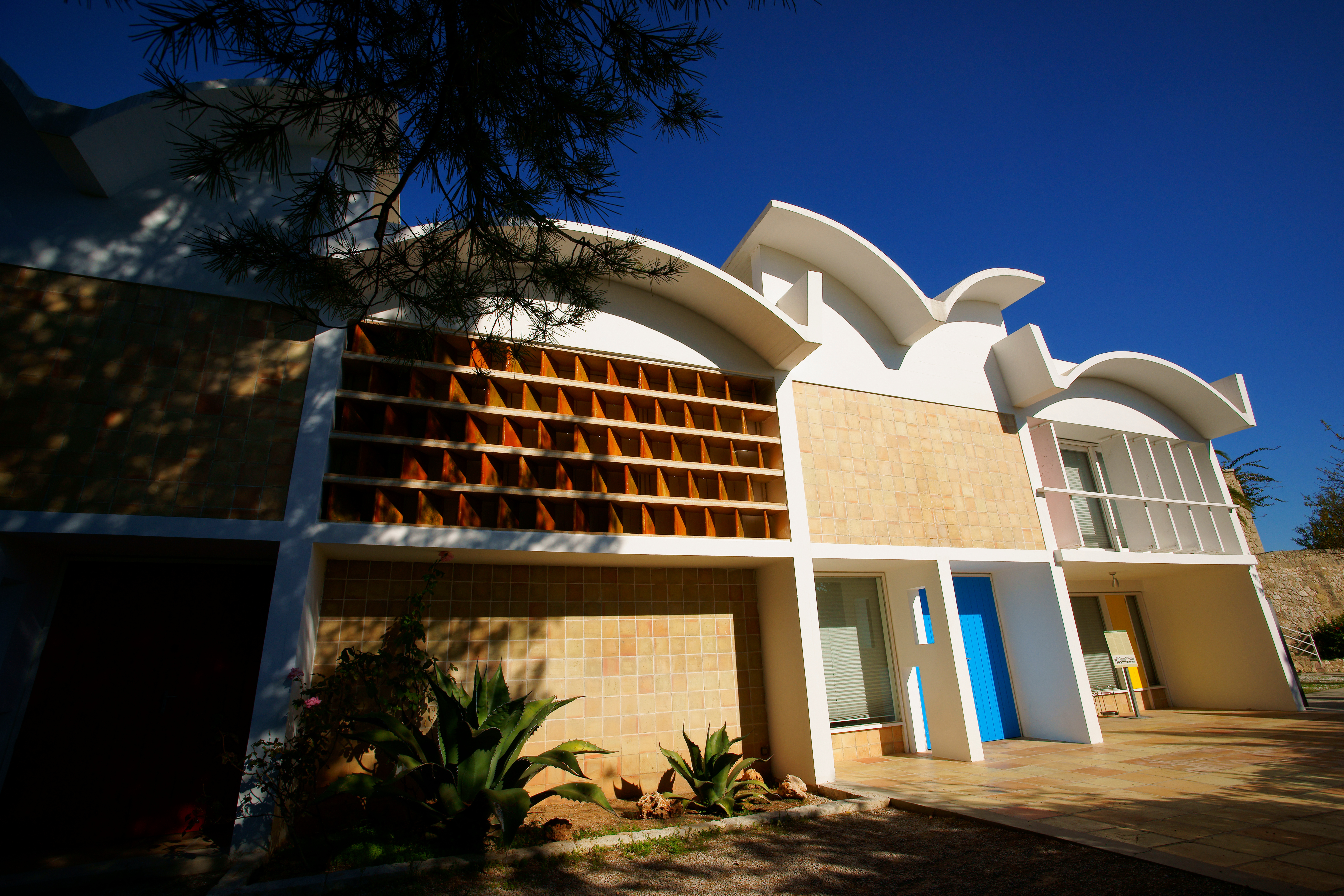a building with a blue door and a tree