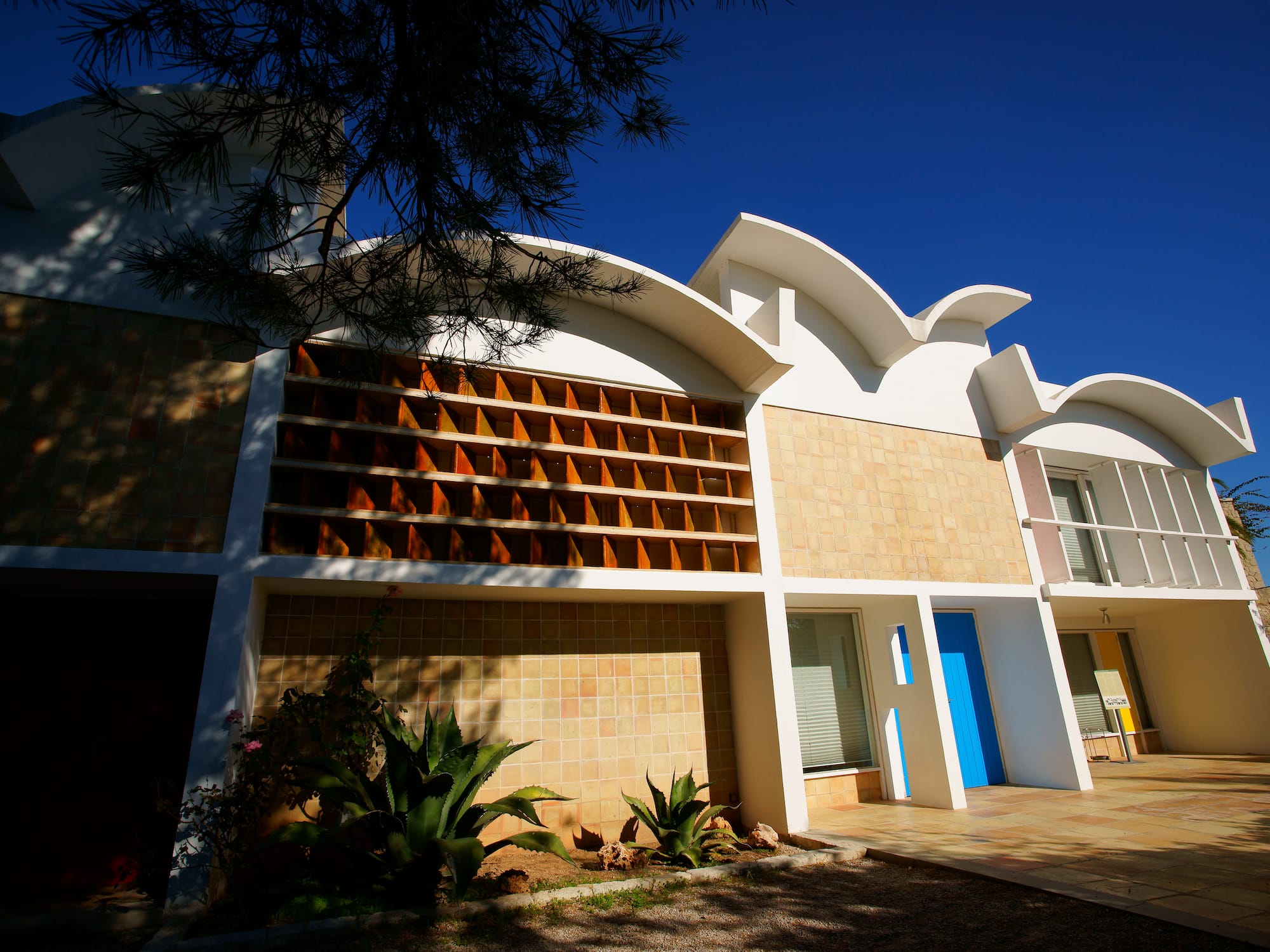 a building with a blue door and a tree