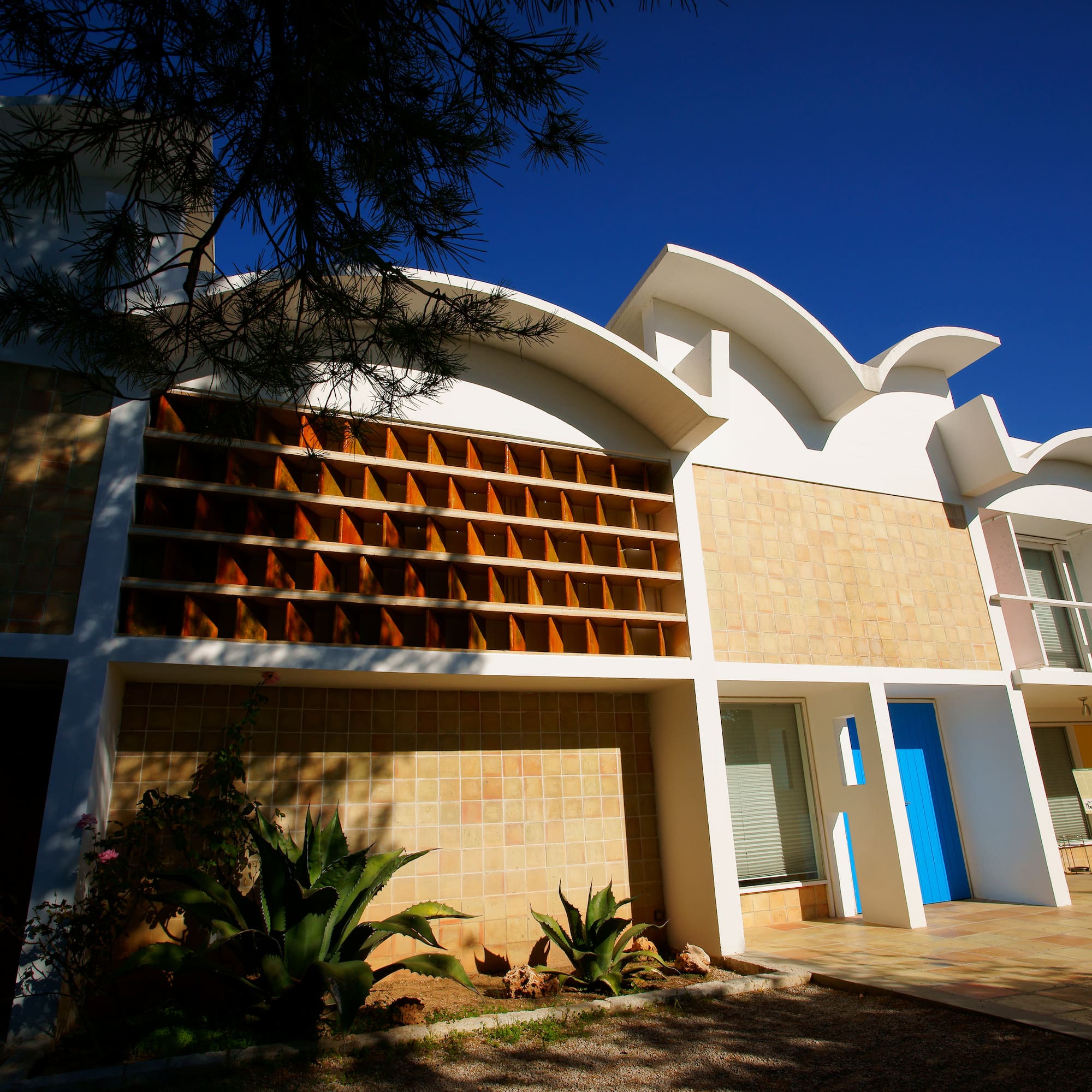 a building with a blue door and a tree