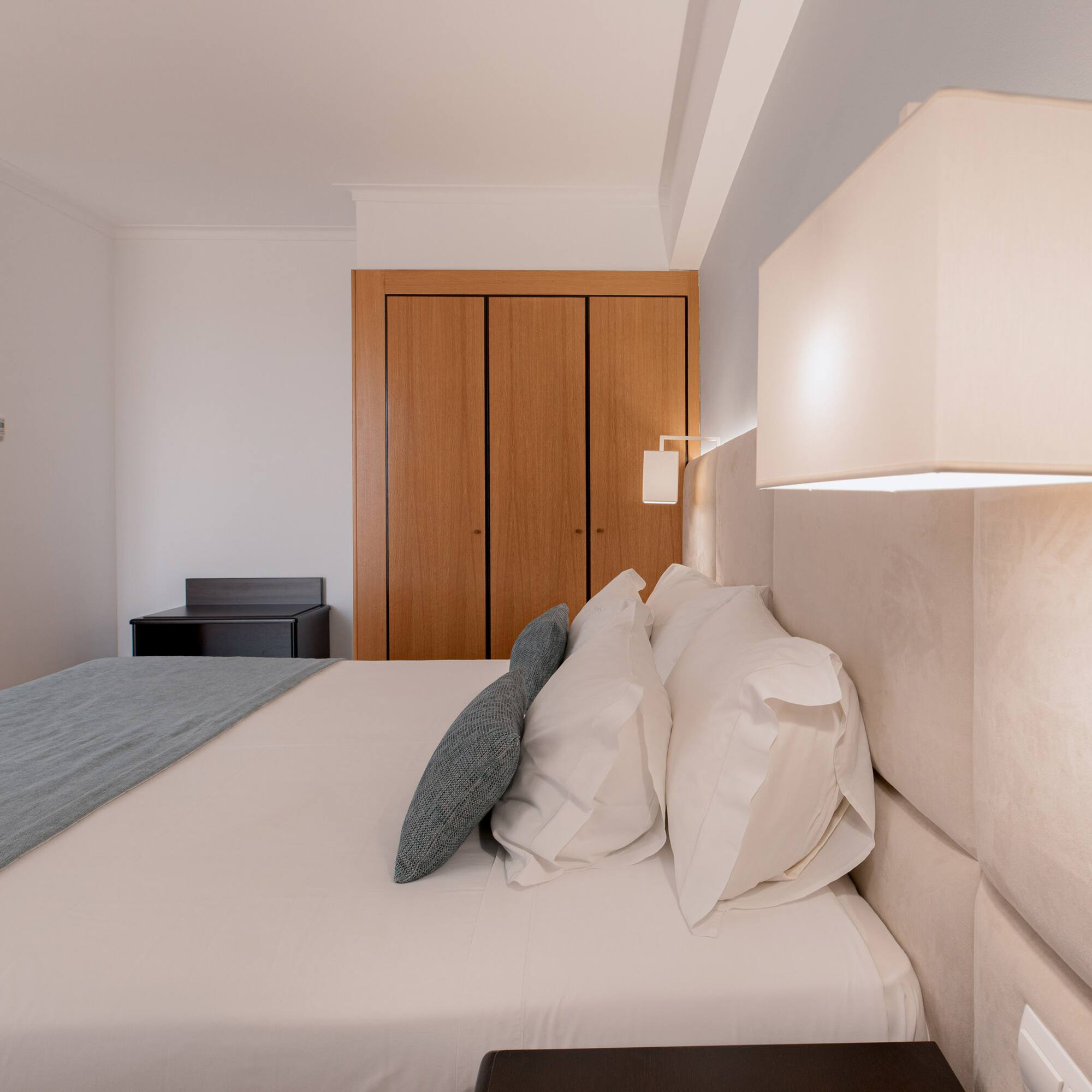 a bed with a lamp and a closet