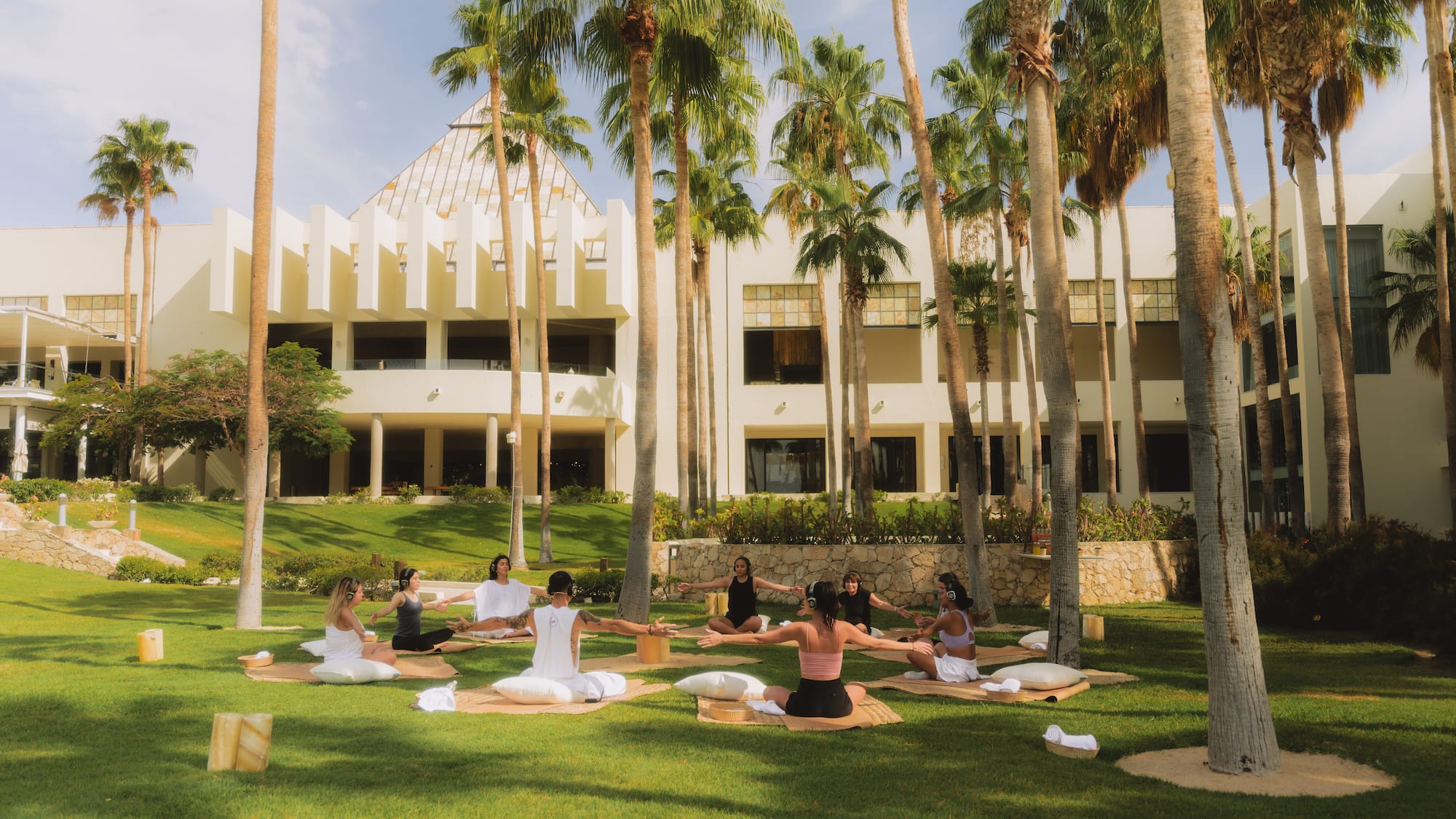 a group of people sitting on mats in a park