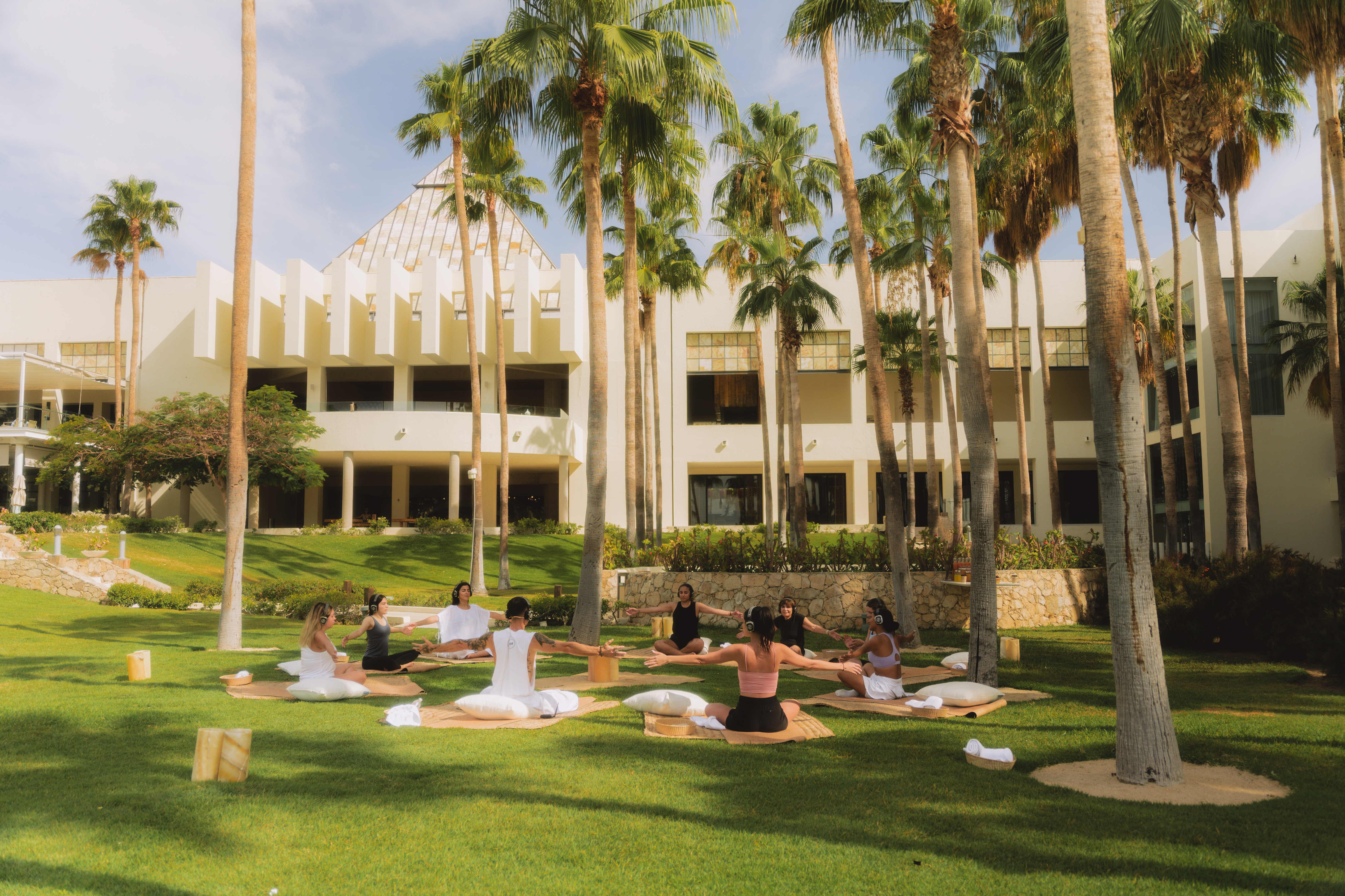 a group of people sitting on mats in a park