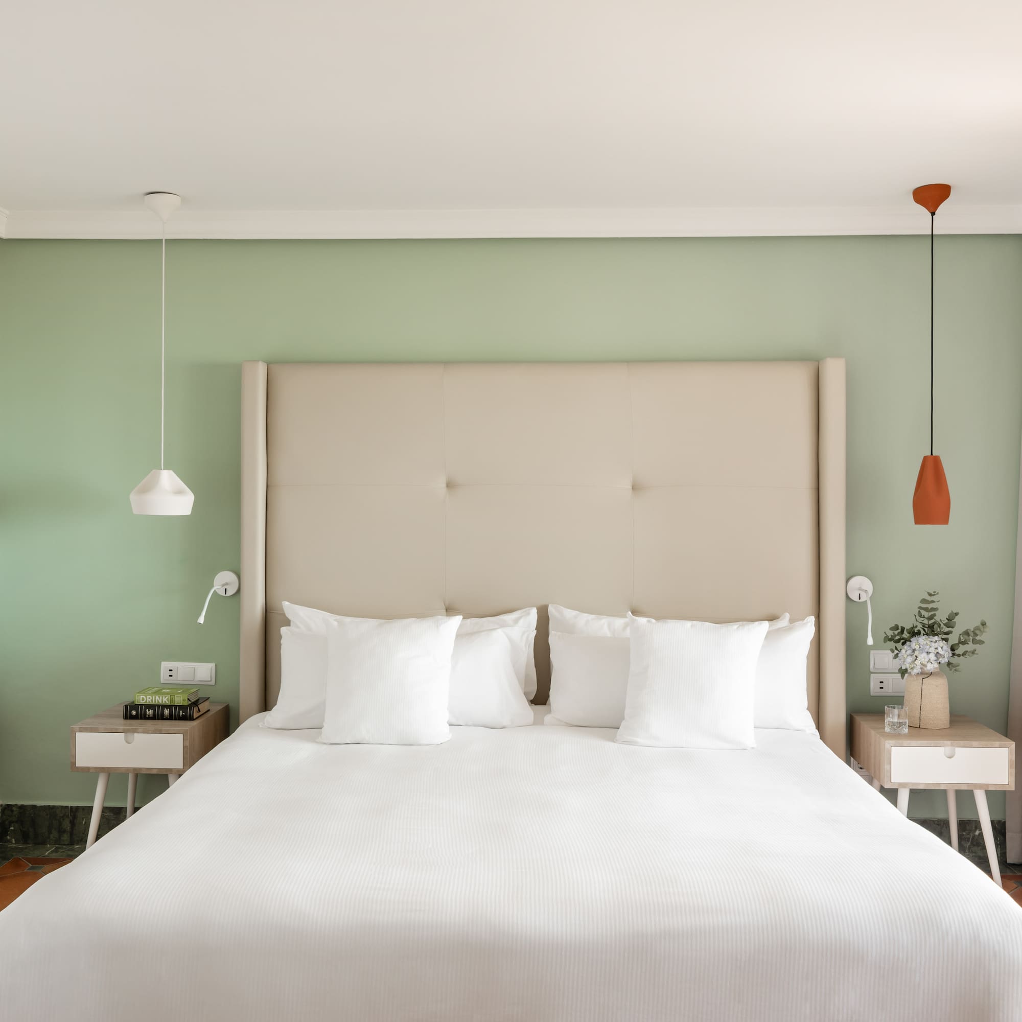 a bed with white pillows and a green wall