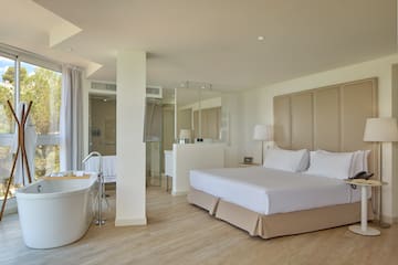 a room with a large bed and a tub