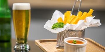 a basket of fries and sauce on a tray