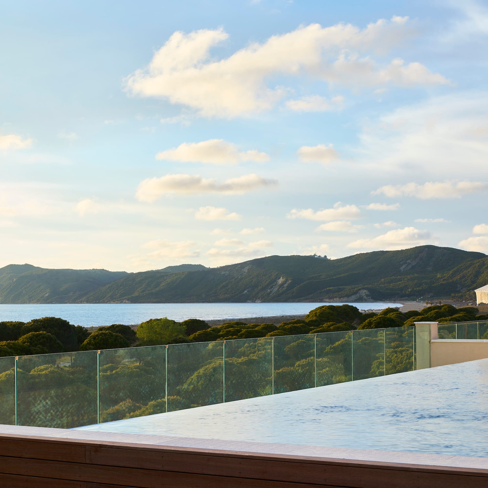 Infinity pool with ocean and mountain views at a luxury resort.