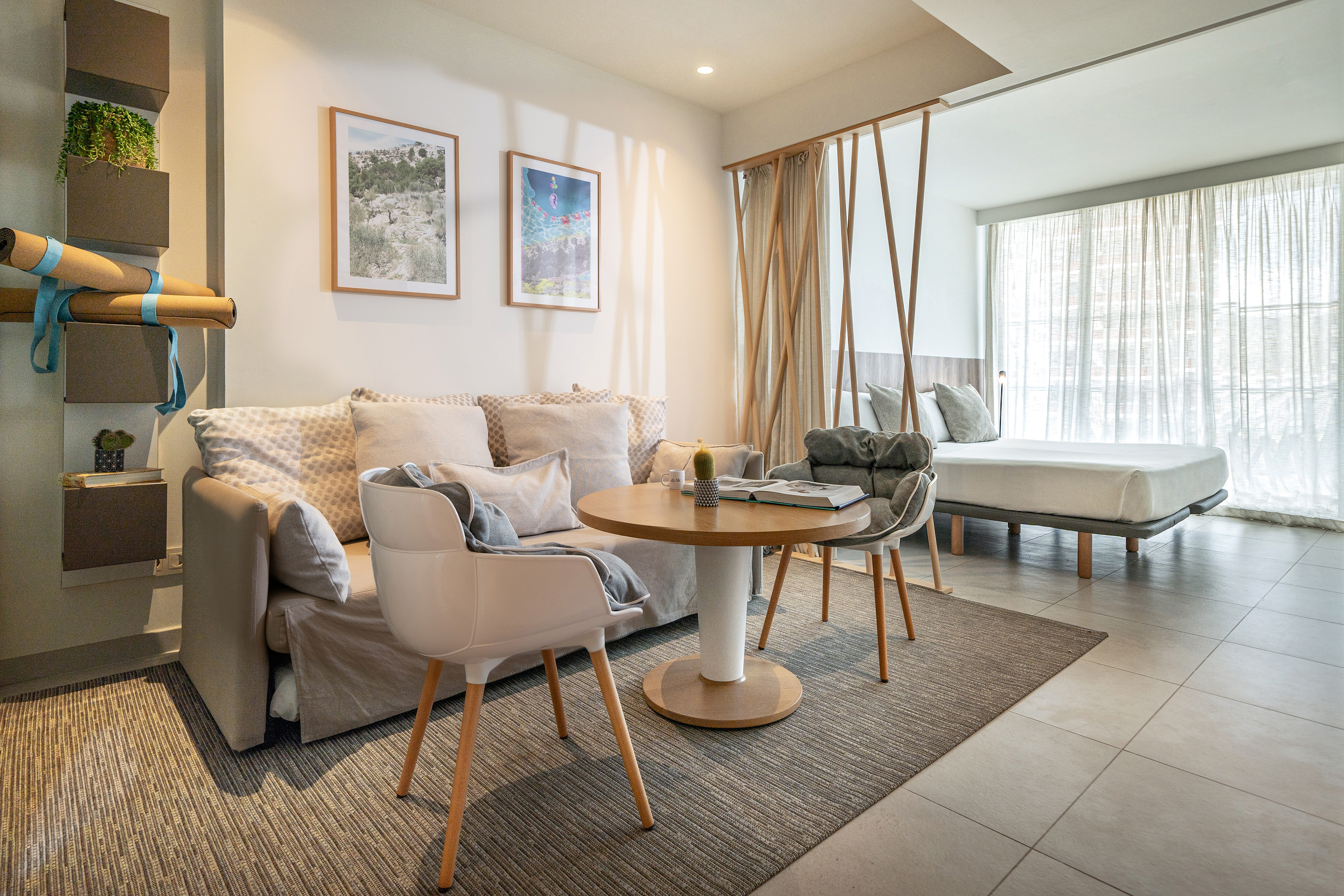 Modern studio apartment living area with sofa, coffee table, and bedroom.