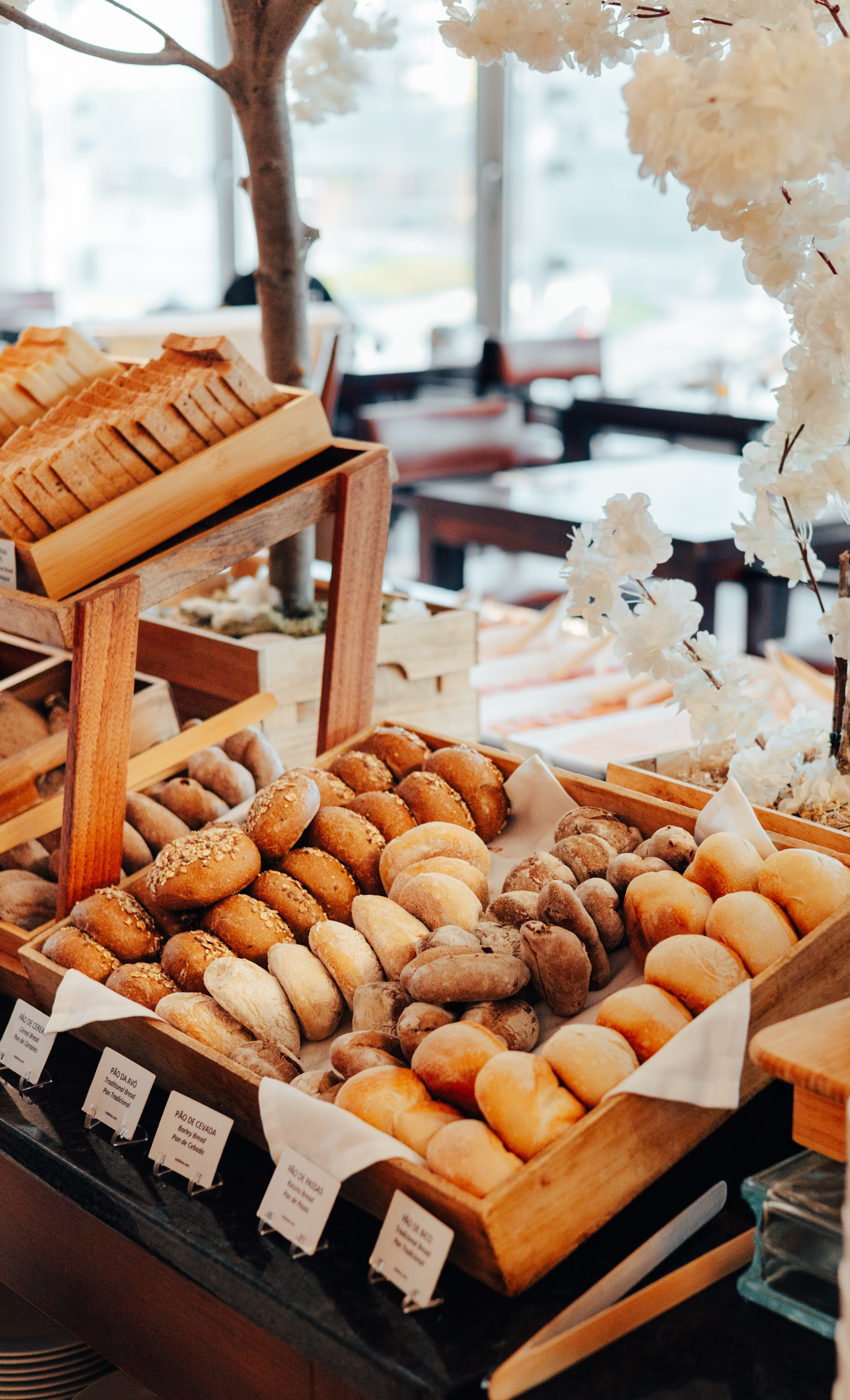 Freshly baked bread rolls, sliced bread, and cereal bread on a buffet.