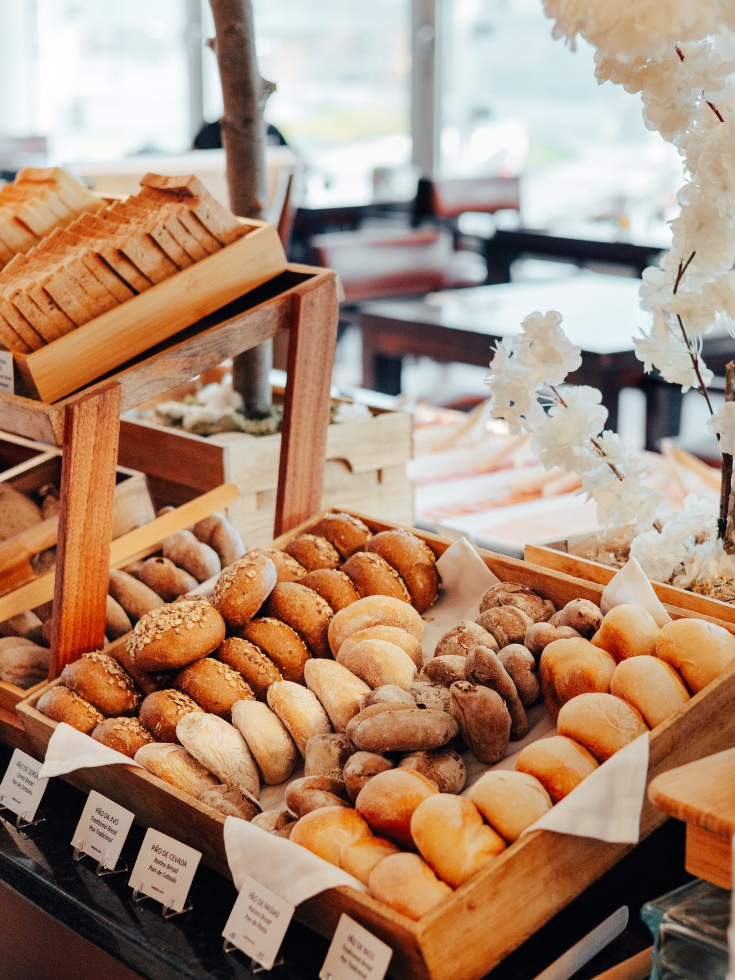 Freshly baked bread rolls, sliced bread, and cereal bread on a buffet.
