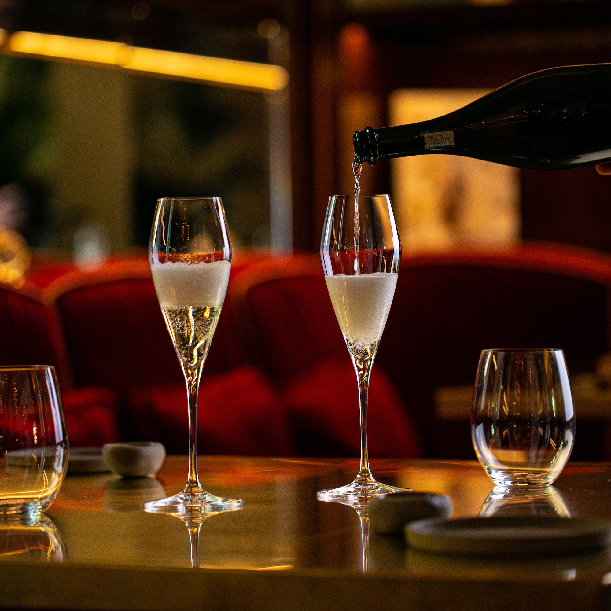 a person pouring champagne into a glass