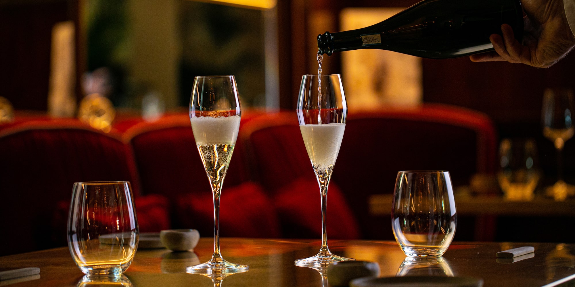 a person pouring champagne into a glass