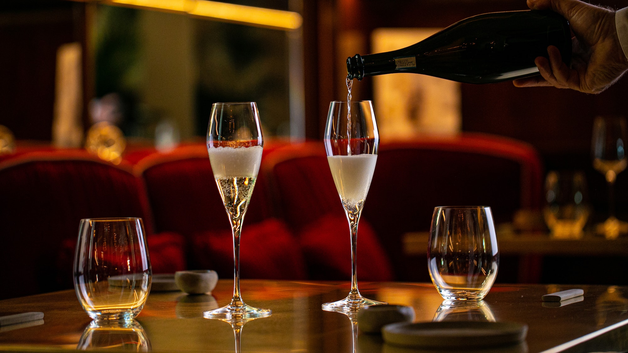 a person pouring champagne into a glass