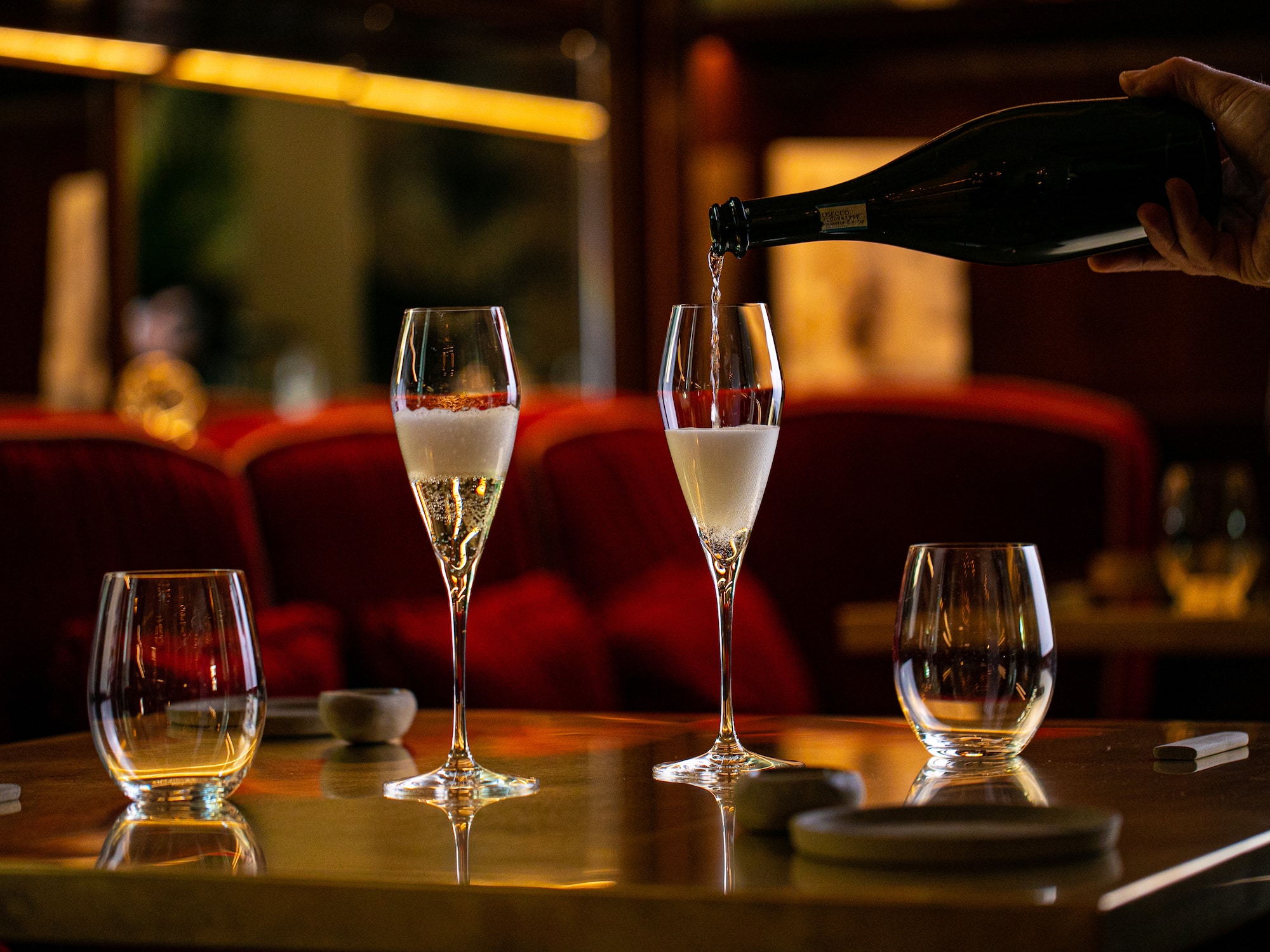 a person pouring champagne into a glass