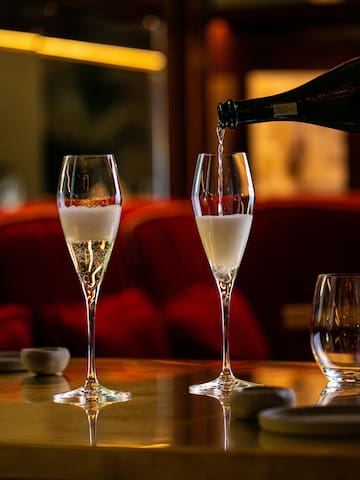 a person pouring champagne into a glass