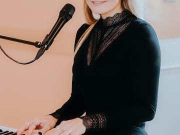 a woman playing piano with a microphone