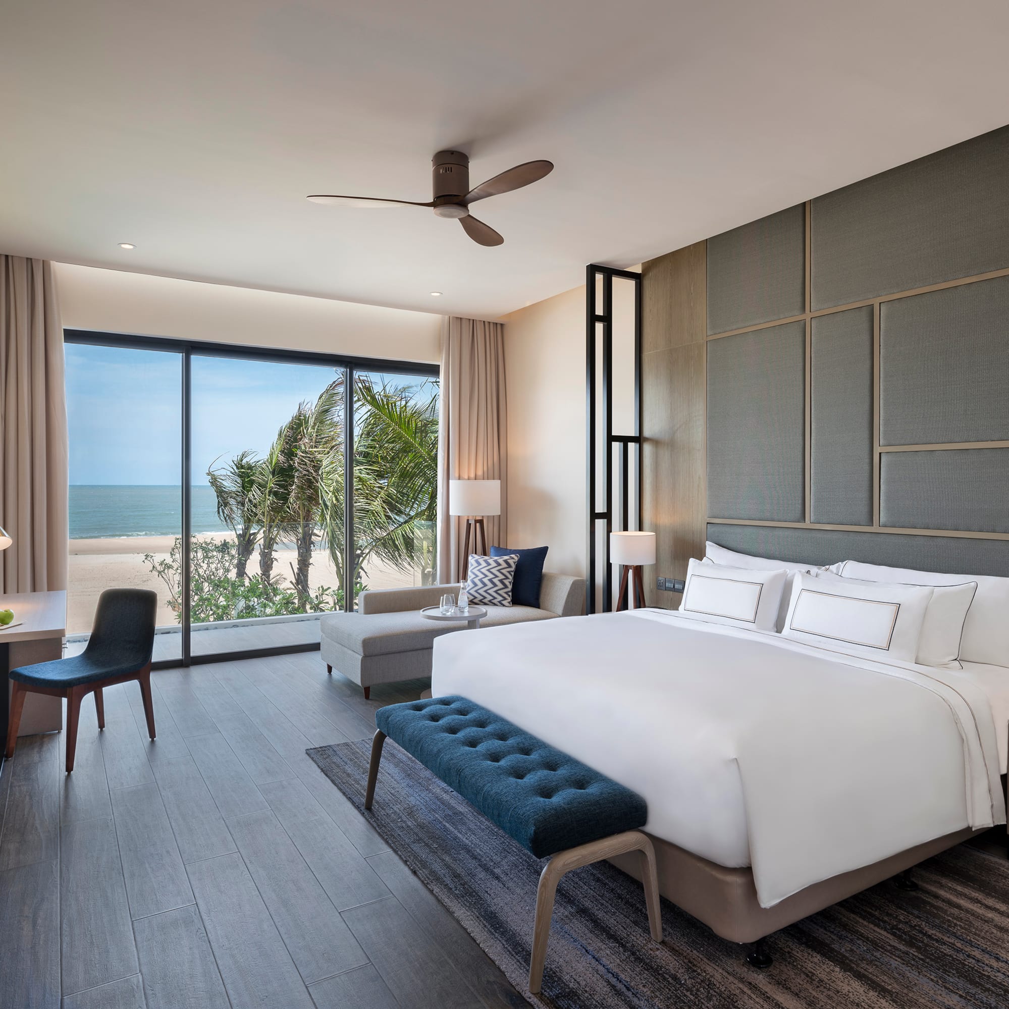 Modern hotel bedroom with ocean view, king bed, and stylish interior.