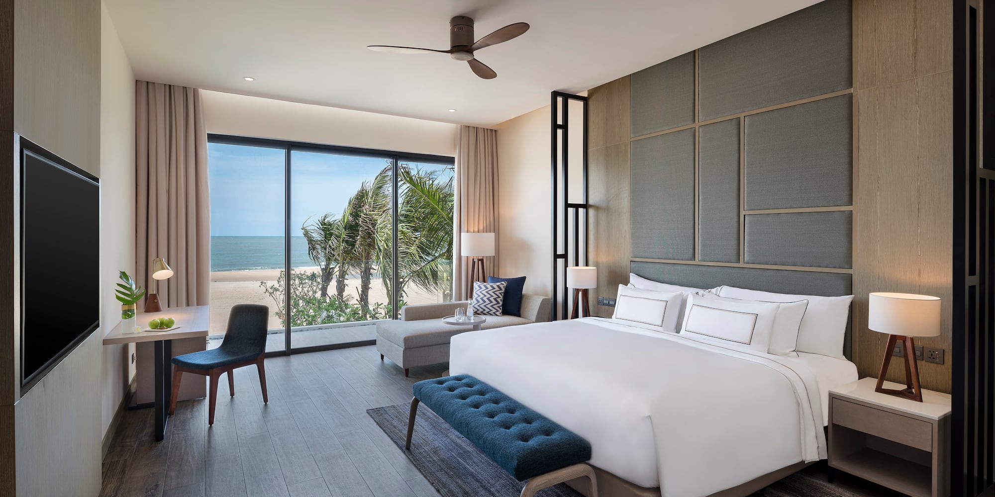 Modern hotel bedroom with ocean view, king bed, and stylish interior.