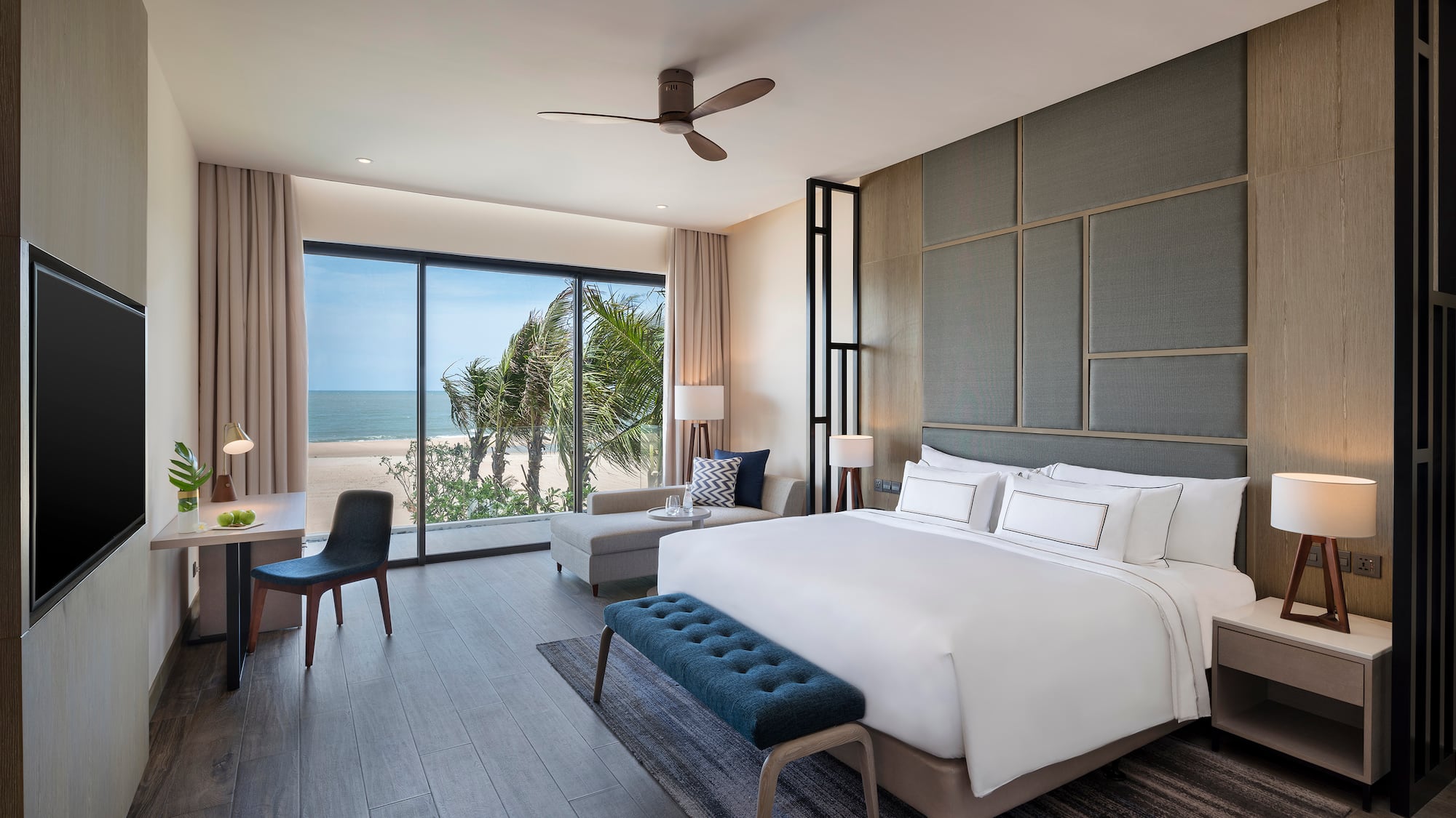 Modern hotel bedroom with ocean view, king bed, and stylish interior.