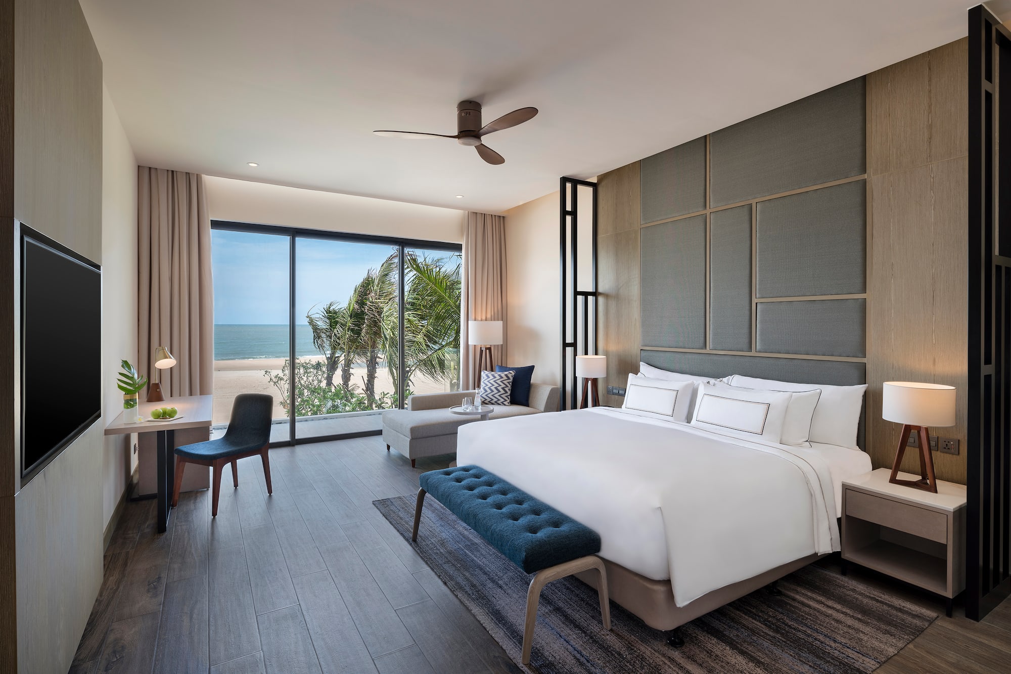 Modern hotel bedroom with ocean view, king bed, and stylish interior.