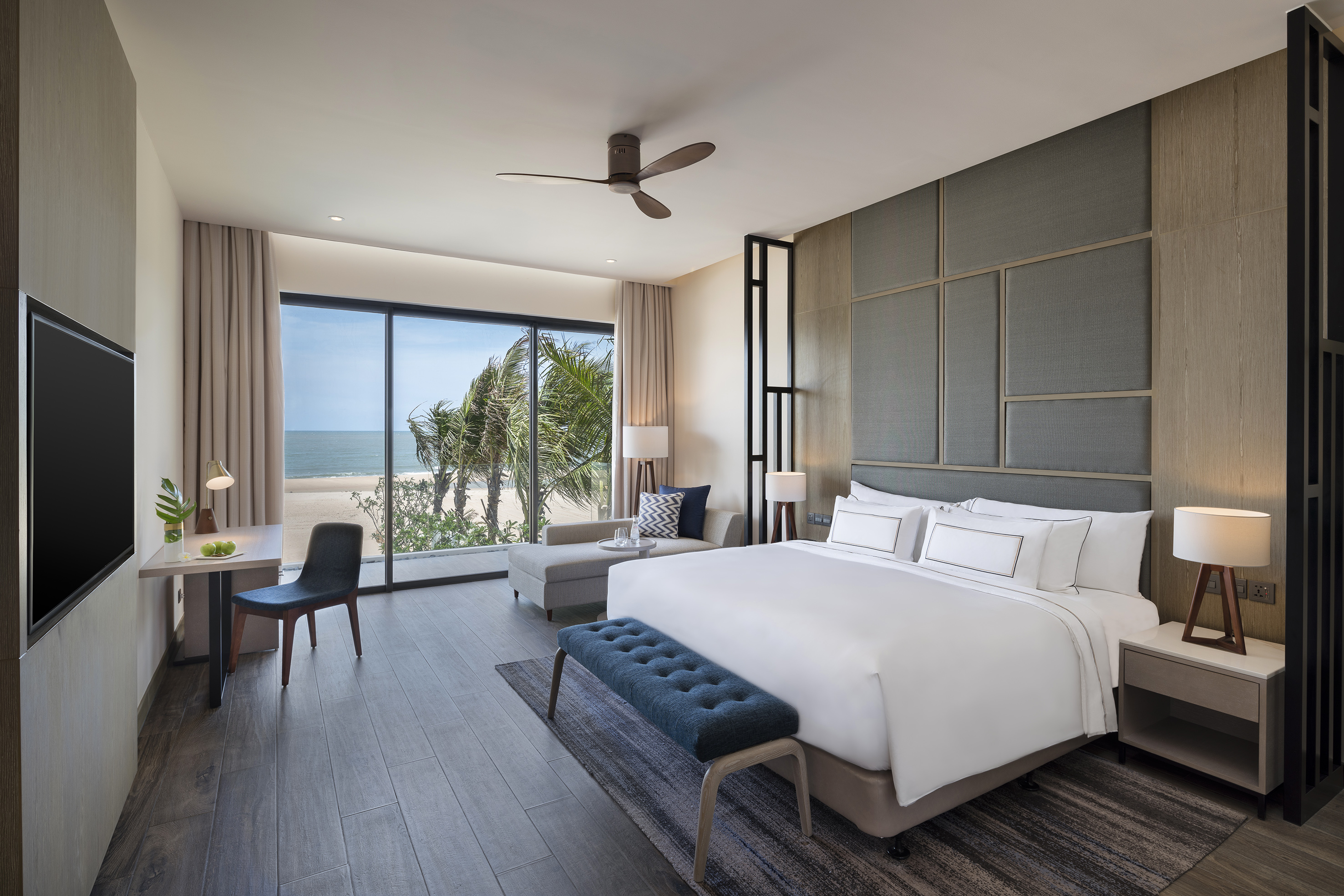 Modern hotel bedroom with ocean view, king bed, and stylish interior.