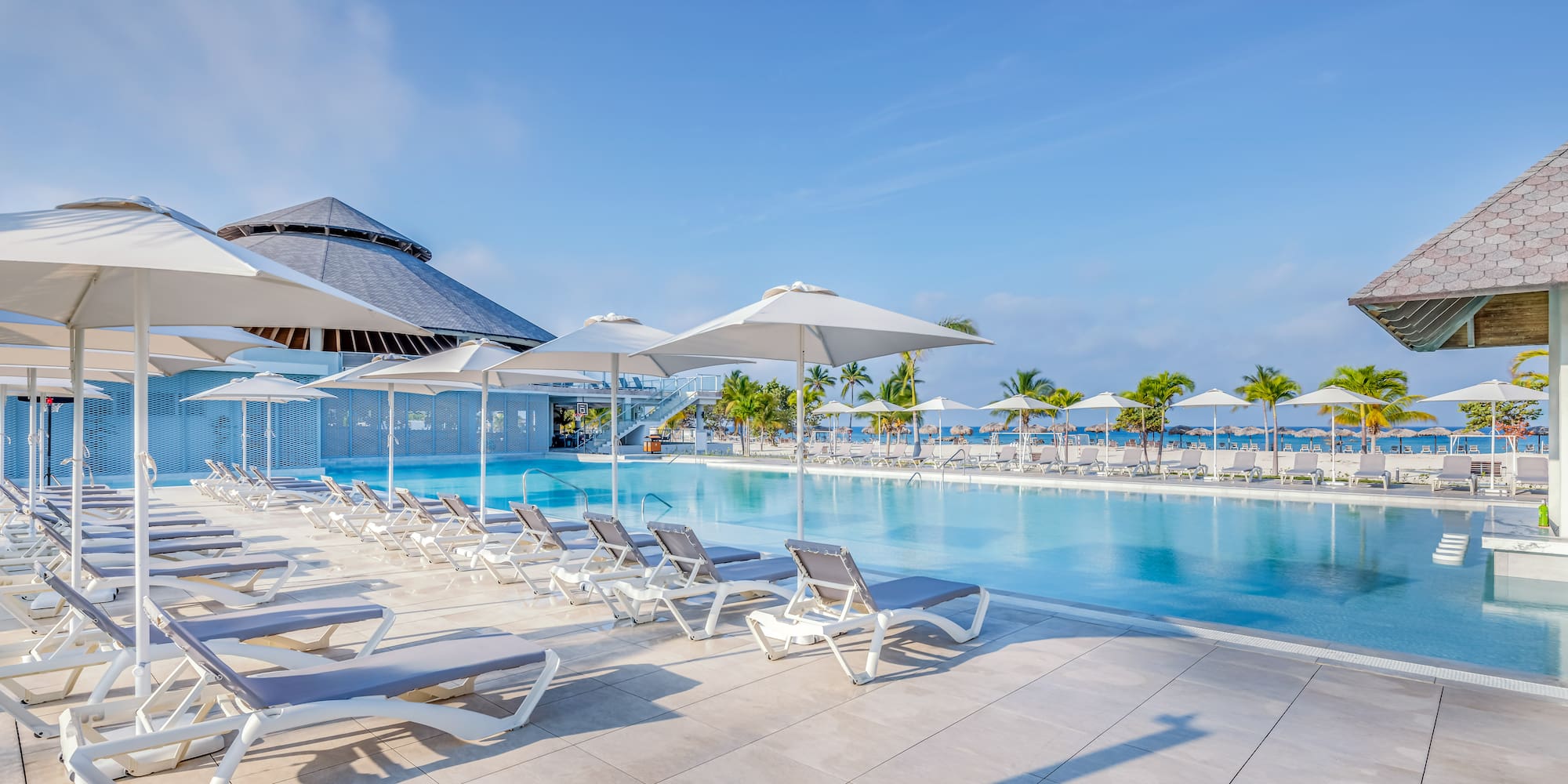 a pool with lounge chairs and umbrellas