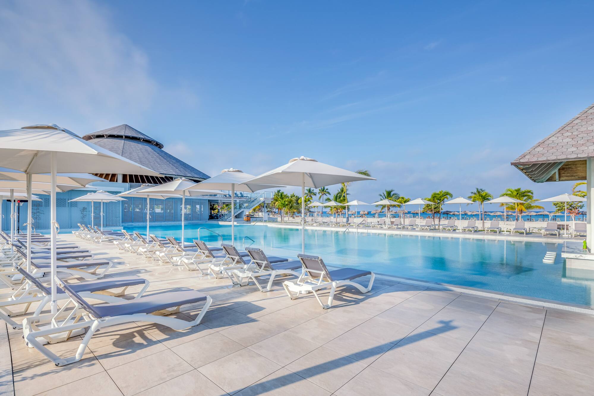 a pool with lounge chairs and umbrellas