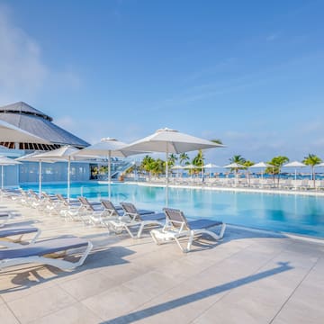a pool with lounge chairs and umbrellas