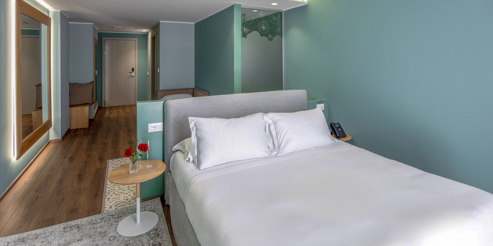 a bed with white sheets and a rug in a room