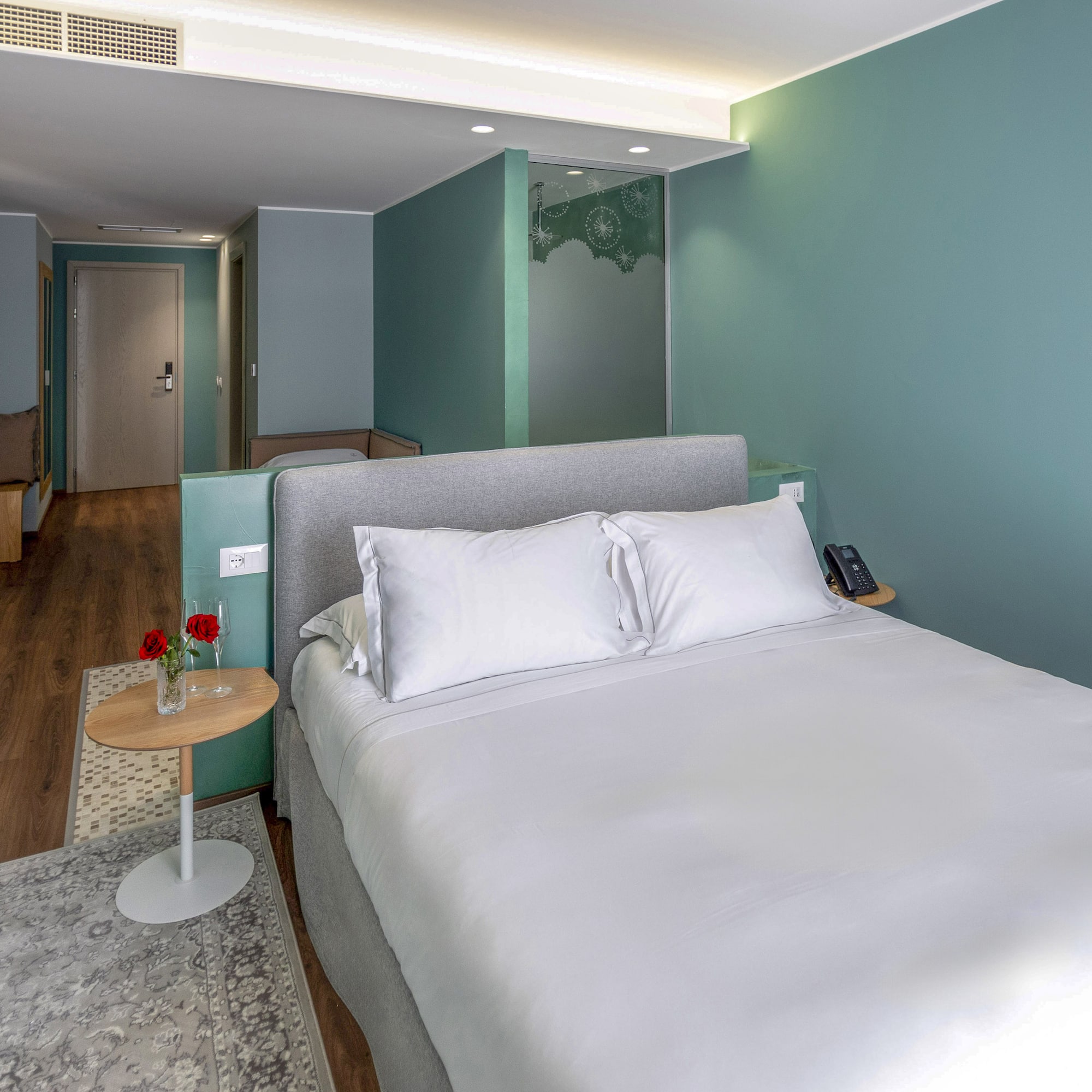 a bed with white sheets and a rug in a room